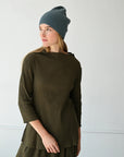 Woman wearing a Norfolk Blue 8.6.4 cashmere beanie with an olive green skirt set