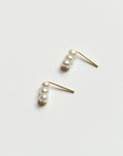 Pair of 8.6.4 freshwater pearl stud earrings on white background.
