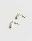 Pair of 8.6.4 freshwater pearl stud earrings on white background.