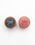 Top view of Abature Plumping Lip Serum and Wild Strawberry Lip Scrub lids