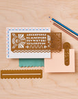 Art deco stencil and brass wavy ruler on patterned note cards with pencils