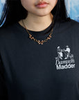 Woman wearing vintage,Van Dell two-toned rose and yellow gold-fill necklace with three sculptural bows on a 15" chain over a black, graphic tee.