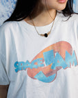 Close up of woman wearing gold-fill necklace with central onyx stone and wing-like leaf shaped design with a 16 inch gold fill chain on a white graphic tshirt