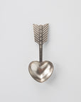 Metallic heart-shaped spoon with arrow design and 'COFFEE' text on a light gray background