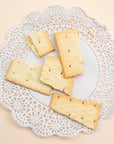 Square olive oil and sea salt crackers on a white lace doily