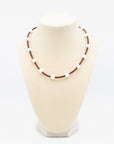 Handmade pearl and leather cord necklace displayed on a jewelry bust