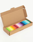 Rainbow gradient dominoes lined up in their open kraft box