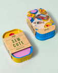 Block Design Sew Cute sewing kit tin in its kraft sleeve, stacked on a second tin