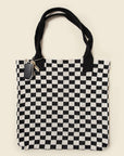 Checkered knit tote bag with black handles on a beige background