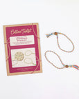 Cotton Twist friendship bracelet kit in pink packaging beside a finished braided bracelet