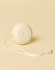 Counterpart white wall charger with its flat USB-C cord pulled out, on a cream background