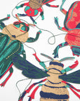 Close-up of hand screen-printed paper beetles and a bee in teal, red and metallic gold