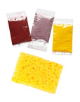 Packets of dried red, purple and yellow herbal inclusions with a yellow sponge from the paper kit