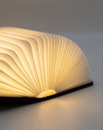 Close-up of the book light open like a book, with pleated white paper pages glowing