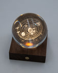 Gingko planetary crystal light glowing amber on its walnut base with a front button