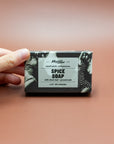 Hand holding a boxed bar of Mayron's Goods Spice Soap with clove bud and ground oats