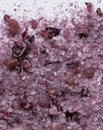 Close-up of pink Himalayan bath salts mixed with dried rose petals