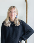 Woman posing in a black sweater while wearing Nach Bijoux's Frost Flower earrings