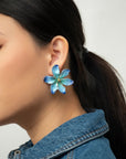 Woman with a ponytail and denim jacket wearing a blue porcelain Frost Flower earring