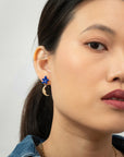Woman wearing the Once in a Blue Moon earring with a blue flower stud and gold crescent moon