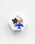 Once Upon a Time adjustable ring with a blue swallow, black flower and white star on a stand