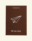 Off the Grid travel journal cover in brown with a white paper airplane drawing