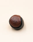 Single brown leather O-Sack hacky sack with a black panel and stamped logo