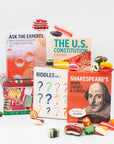 Colorful display of four card decks: Ask the Experts, The U.S. Constitution, Riddles Vol. 1, and Shakespeare’s Quips, Cusses and Curses, surrounded by bright vintage candies
