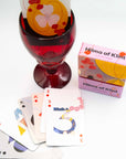 Hilma af Klint playing cards with a red glass and box on a white background