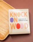 Knock on Wood quiz deck of common customs in a wood-look box on a wooden board