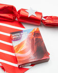 Where in the World Are You? situation card deck box in front of a red holiday cracker