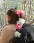 girl wearing pink and white organza "cloud" scrunchies, leaning against another girl in the park