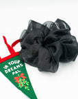 Oversized, black organza scrunchie next to a felt holiday banner with misletoe