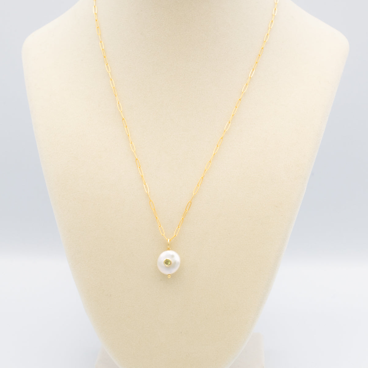 Pearl with set-in peridot gemstone on a gold paperclip chain necklace