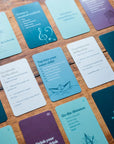Self-care adventure cards spread on wood, with prompts like Go the distance