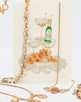 Vintage fancy and flirty necklaces featuring pearls, cameos, goldstone and rhinestones draped on a retro greeting card