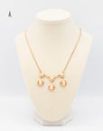 Vintage 1940s gold-fill necklace with three carved shell cameos and gold floral accents with a 16-inch chain on a jewelry bust