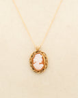 Close up of hand-carved shell cameo, in an intricate, braided, gold-filled setting on an 18" chain