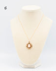 Shell cameo in 10K gold-filled Etruscan Revival frame with forget-me-not accents on 18" gold-filled chain on a jewelry bust