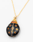 Detailed shot of the black and gold enamel ladybug charm on a twisted rope gold-filled chain