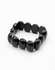 Single black onyx beaded stone bracelet with polished chunky beads photographed flat against a white background.