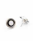 Back view of a pair of round vintage opal earring studs with black and silver rims on a white background
