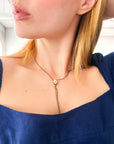 Close-up of a woman wearing a delicate antique gold-fill Chatelaine Necklace with authentic late-Victorian lorgnette chain & pearl with a blue top.