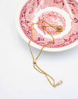 Antique Grand Deco Chatelaine Slider necklace on a decorative plate with intricate designs