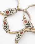 Several Winter Bloom bracelets with white enamel poinsettia links on vintage watch bands