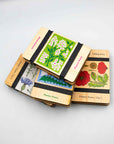 Stack of Studio Wald wooden flower presses in assorted botanical prints