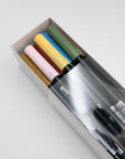 Open box of Tombow dual brush pens in pink, yellow, blue and green on a white background.