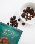 Masala spiced dried cranberries in a white bowl next to the Varah pouch
