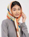 Model wearing the striped knit triangle scarf as a headscarf