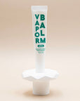 Zizia Vapor Balm tube in white with green lettering, standing on its cap